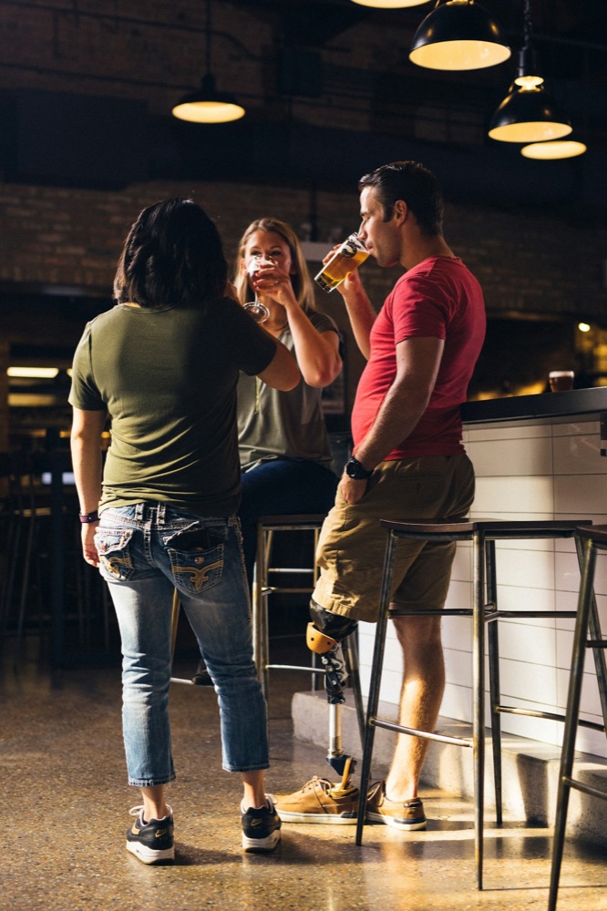Three friends raising glasses at a neighborhood bar